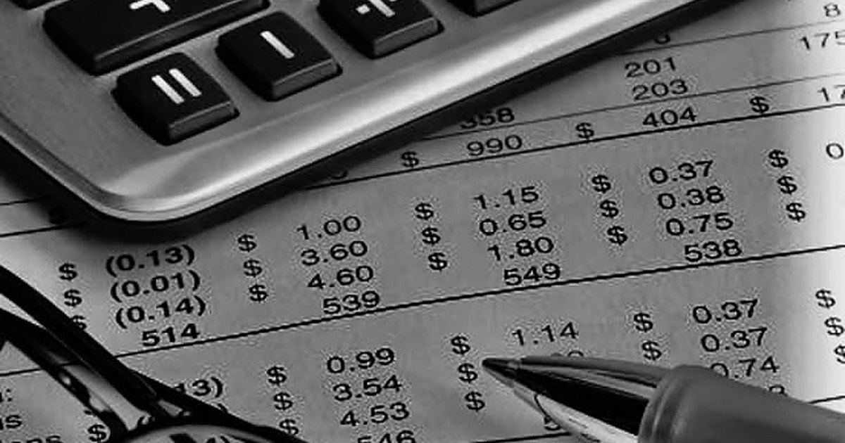 Calculadora y pluma sobre un estado financiero con cifras